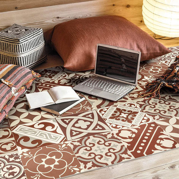 Large vinyl floor rug in an orange tiled pattern with cushions and a laptop on top