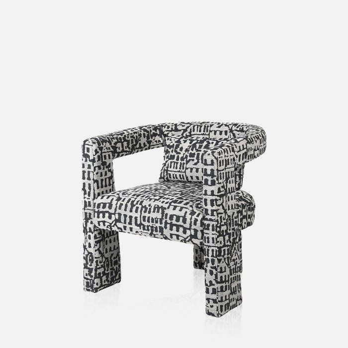 A cutout of the Bushwick Occasional Chair, a three-legged modern chairwith a black and white abstract pattern.