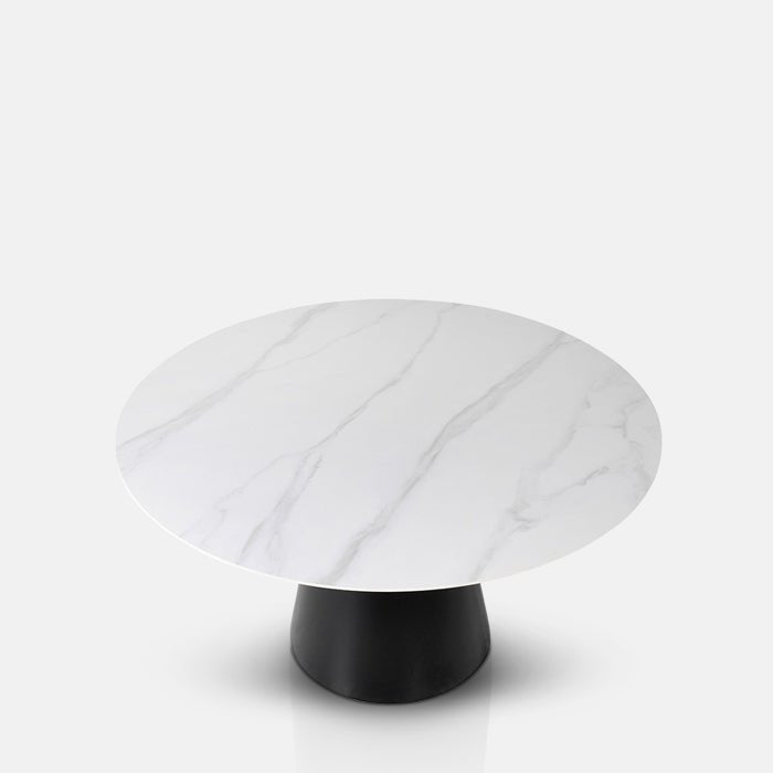 A cutout of the Caldwell Dining Table. A round faux carrara marble top on a chunky black metal base table.