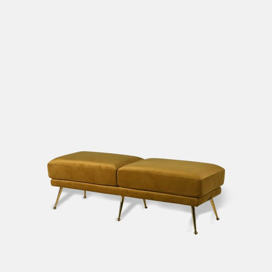 Large bench upholstered in mustard yellow velvet, supported by six gold metal legs.