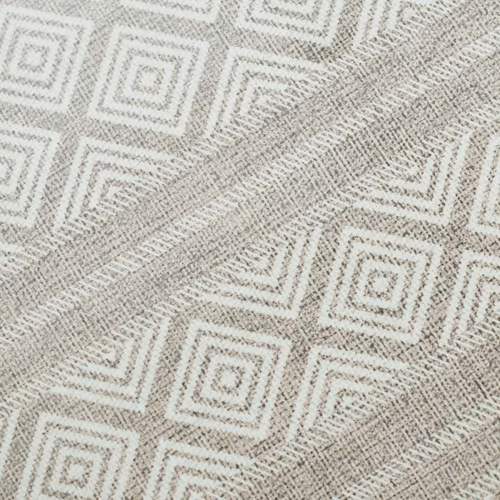 A close up of the Canta Vinyl Flooring, a diamond and striped pattern vinyl rug in a beige and light brown hue.