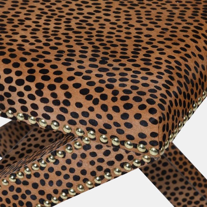 A closeup of the leopard print pattern and stud edging detail on the Chester Leopard Print Stool.