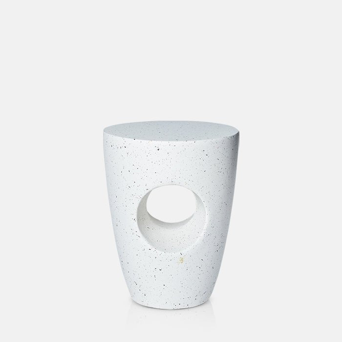 Cutout image on a white background of a curved, white side table that works both indoors and outdoors. The white side table has a circular cutout that runs through the centre of the base.