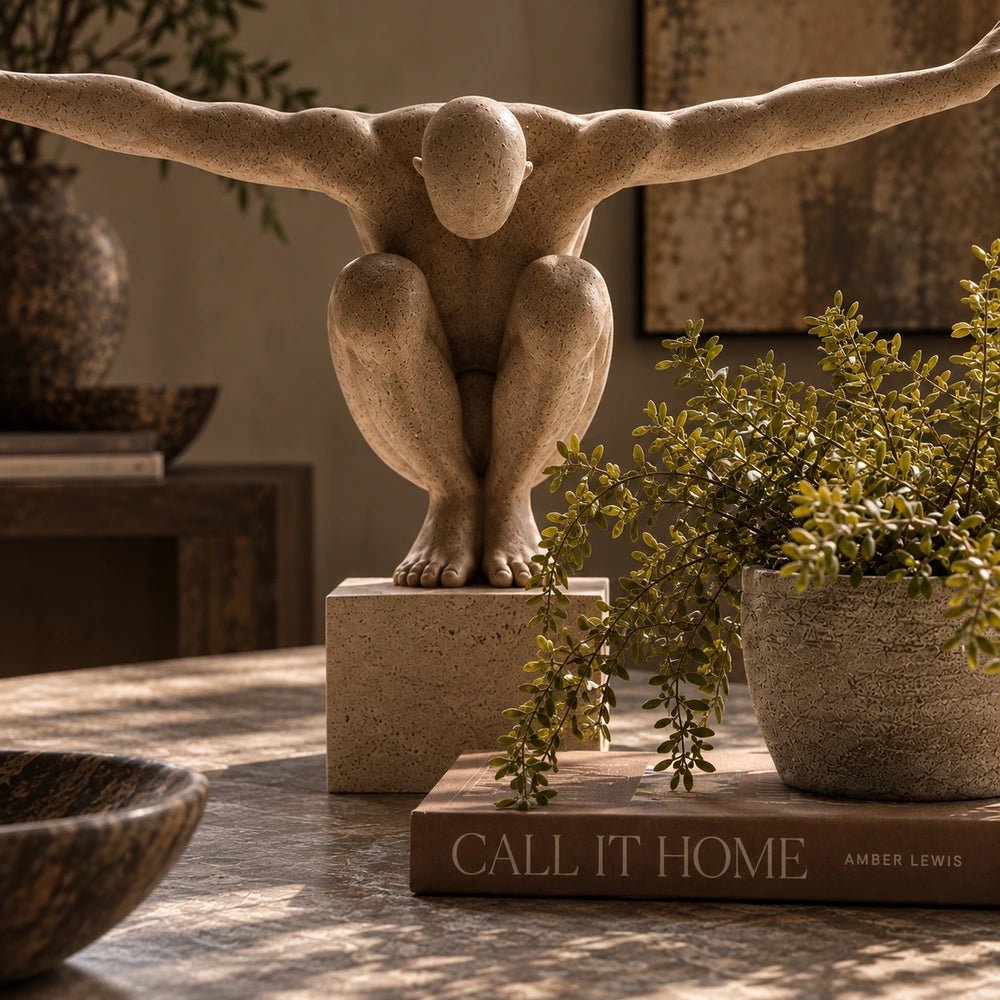 Close-up of the Croyde Figurative Sculpture on a styled table, showing its expressive human form and surface detail among surrounding decorative objects.
