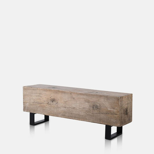 A large bench, made from one solid block designed to look like wood, sitting on two black metal legs.