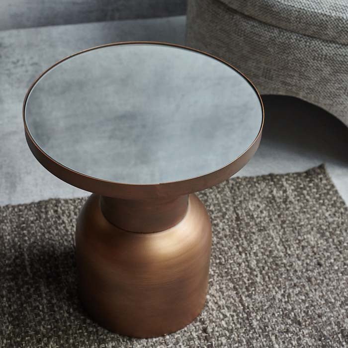Round mirrored table top on a sculpted bronze base