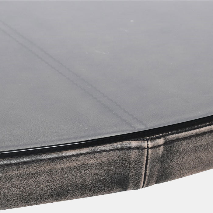 Upholstered leather details and glass table top on a round dining table