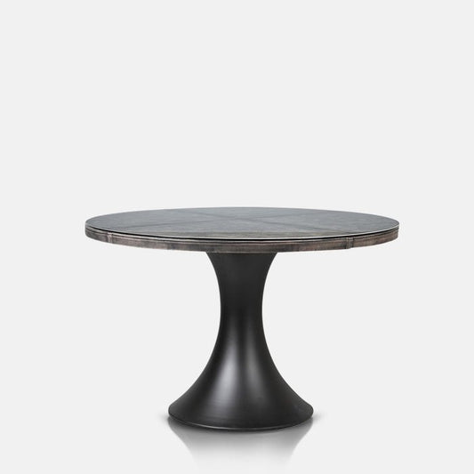 Round, black dining table with a glass top and curved pedestal base