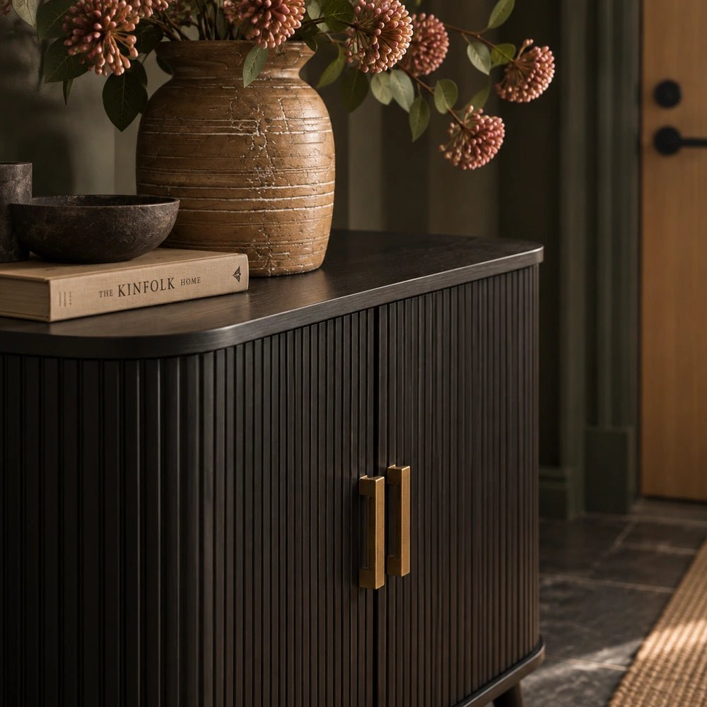 Dolton Wooden Cabinet shown front-on in a warm neutral room, styled with sculptural ceramics and a table lamp to highlight its dark wooden finish.