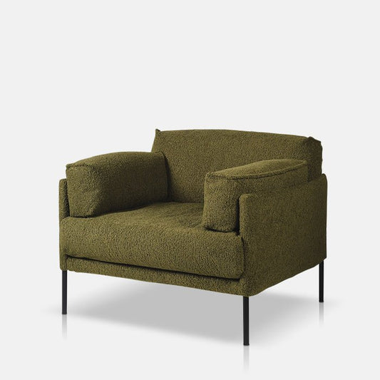 A large boxy armchair in khaki green boucle fabric with metal legs.