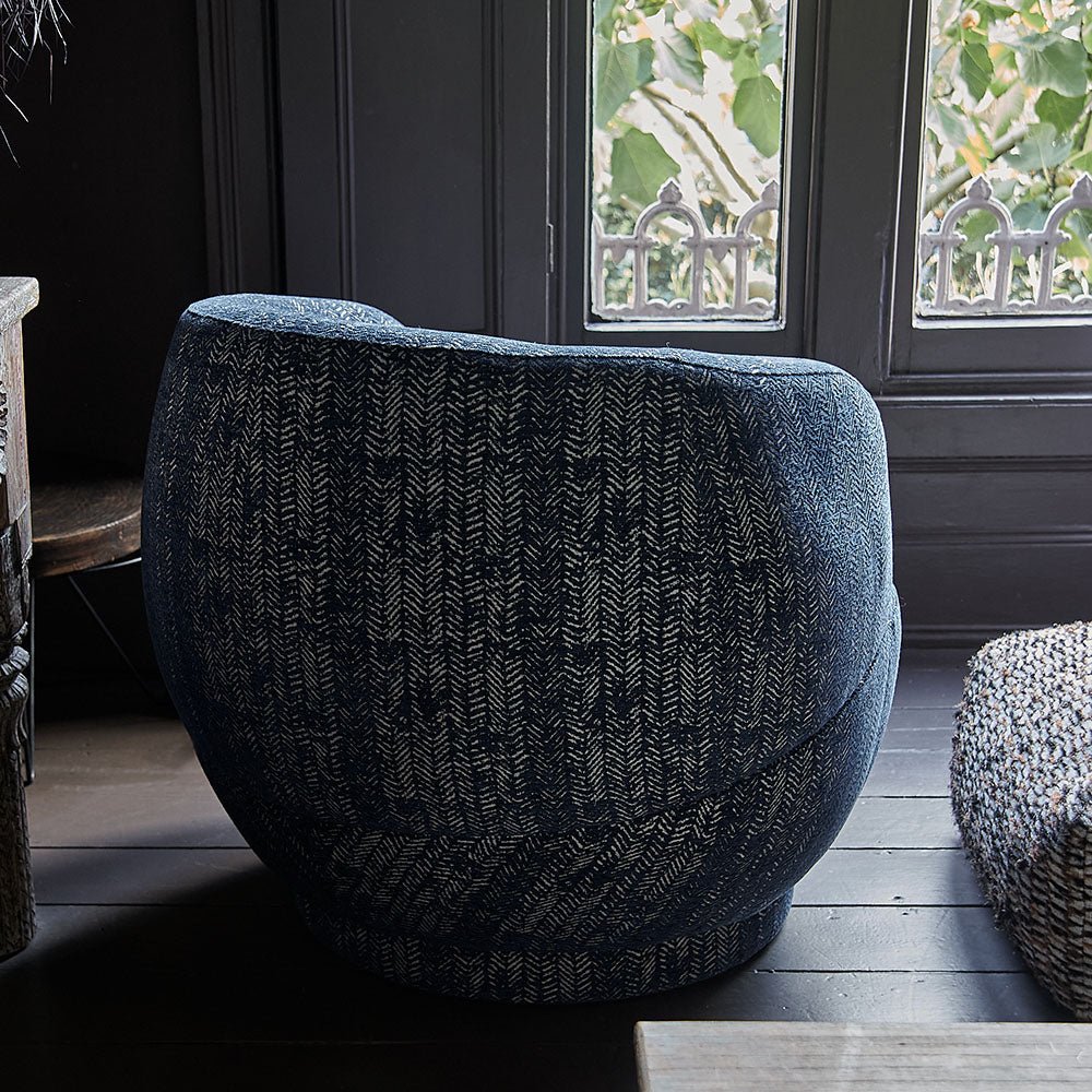 Back of a blue herringbone patterned armchair in a round shape