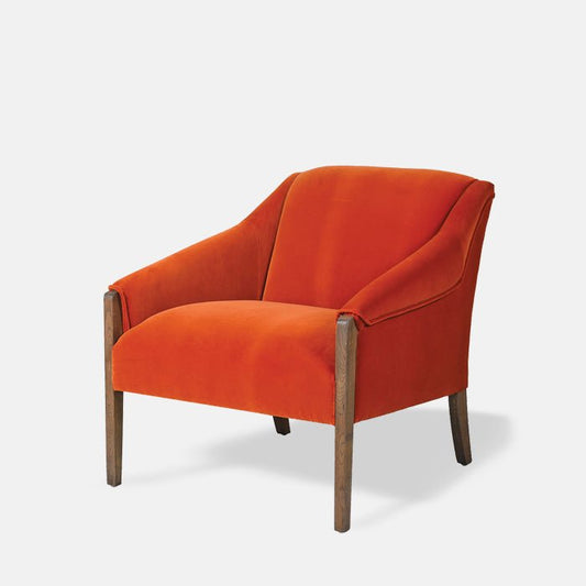 Orange velvet armchair with brown wood legs.