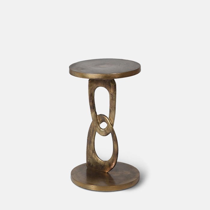 A cutout of the Emilio Side Table, a small round table with a weathered brass effect finish and an usual chain link style pedestal.