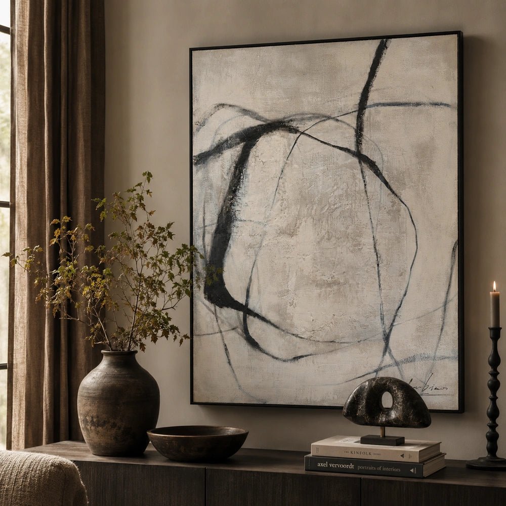 Entangle Canvas Art with monochrome abstract lines displayed above a dark console table, styled with sculptural ceramics, books and foliage in a neutral interior.