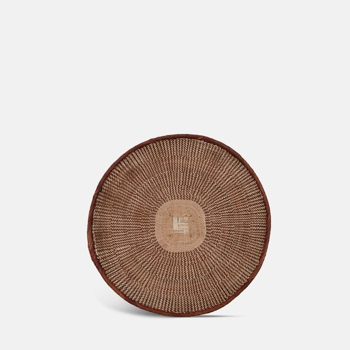 A cutout of the Fallon Basket, a circular wide shallow woven basket with a geometric tribal pattern.