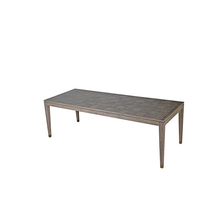 The Frances Dining Table, a long rectangular table in oak veneer with a parquet style surface and slim tapered legs.