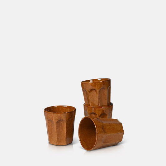 Set of four stoneware tumbler cups in amber brown glaze and fluted design.