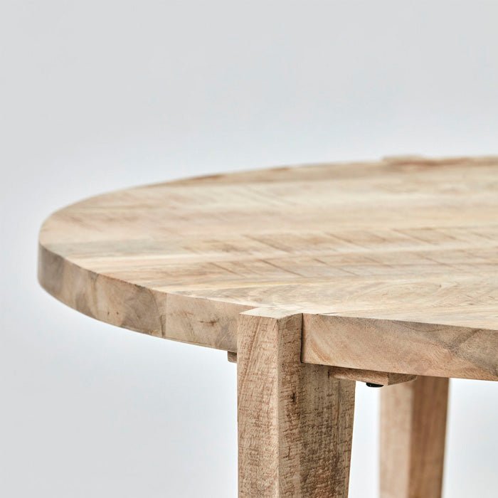 A sleek and modern round coffee table with three legs.