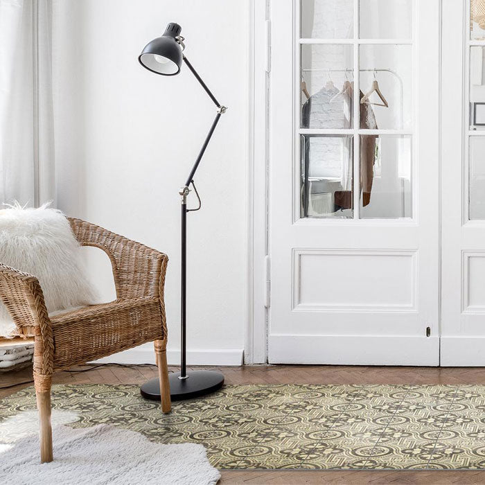 Large tiled patterned vinyl rug rolled out under a brown chair and black floor lamp