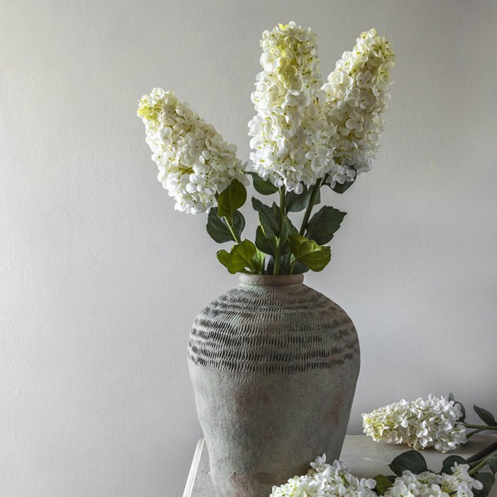 Styled image of a faux bouquet of hydrangea artificial flowers, a great example of Abigail Ahern's fake flowers that look real.