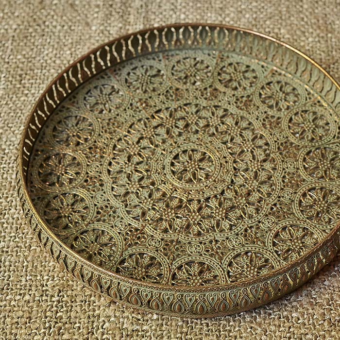 Round metal tray with a cutout pattern and golden details
