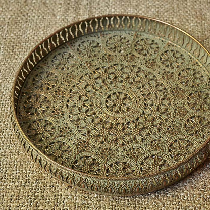 Round metal tray with a cutout pattern and golden details