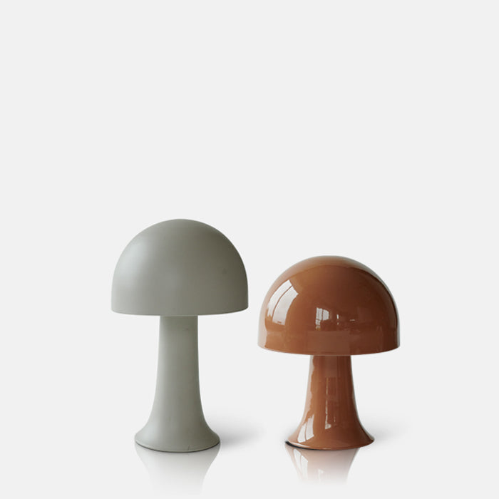 Cutout image of two unlit LED lamps, one brown and shiny and the other matte and a soft, cloud grey. 