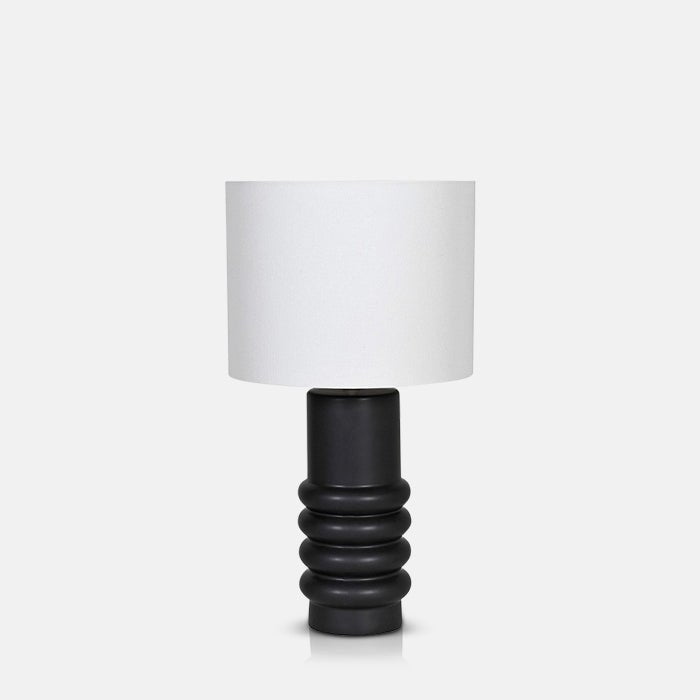 A cutout of the Julia Table Lamp, an abstract ribbed black ceramic base with a white linen shade table lamp.