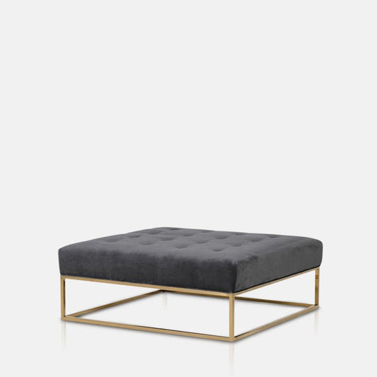 Cushioned grey square ottoman sat on a thin gold frame