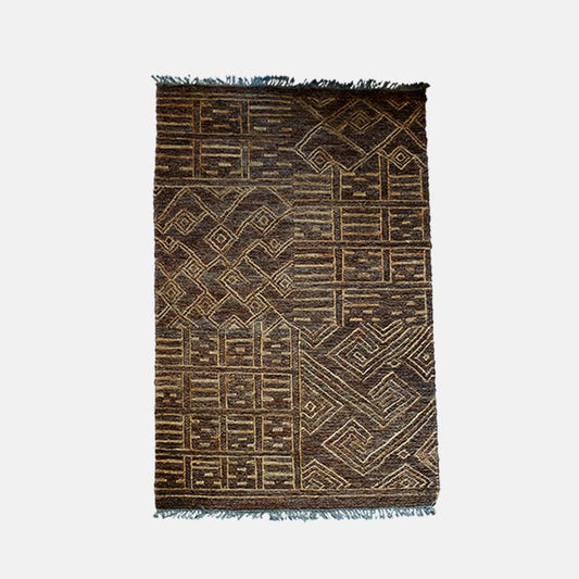 Cutout image on a white background of a warm toned brown rug woven from cotton and jute with a mix of geometric patterns.