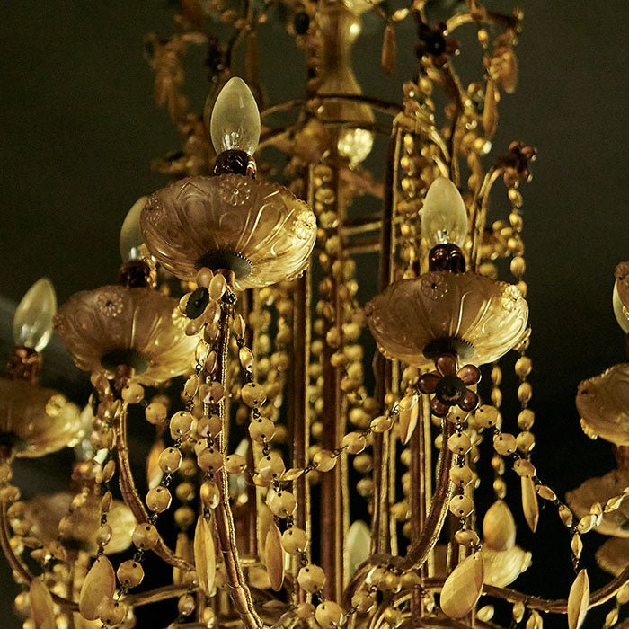 Ornate bulb holders on clear glass chandelier.