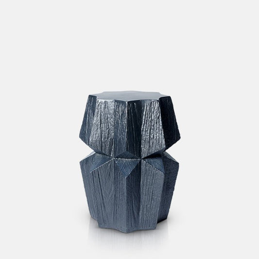 Cutout image on a white background of a chunky, black side table. The modern side table has an angular shape and wood grain style finish.