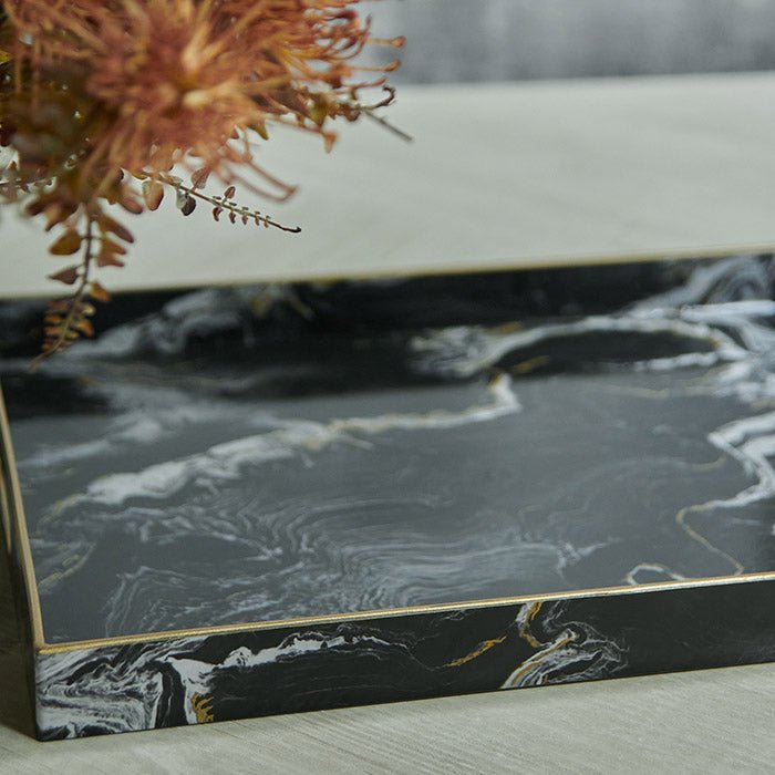 Magnus Trays - Set of 2. A close up ot the black marble effect tray with brass details.