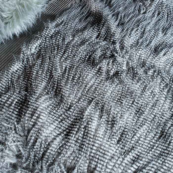 A closeup of the Malton Throw showing the detail of a black stripe across silvery faux fur.
