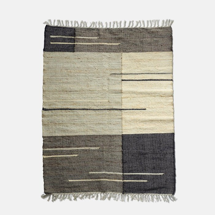 Large jute and cotton rug, with woven block colour design in varying shades of grey and cream, finished with tasseled ends.