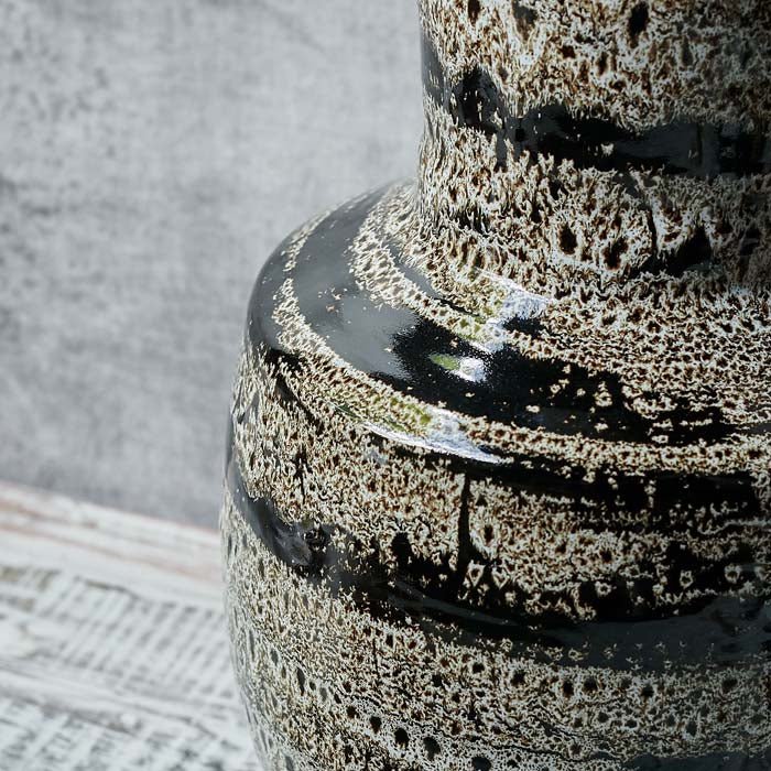 Black, brown and cream marble patterned vase in a round shape