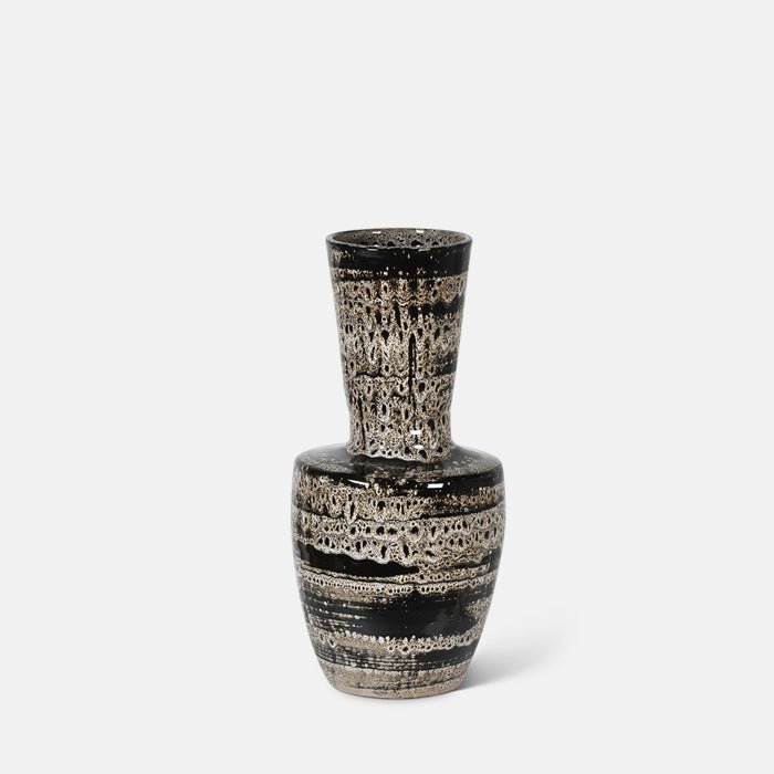 A cutout of the Matumbo Vase, a black and cream sculptural reactive glazed ceramic vase with a speckled and striped pattern.