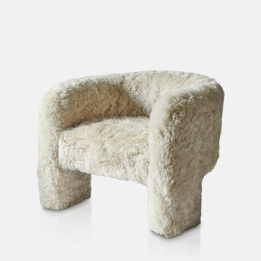 Creamy sheepskin armchair in a curved shape, sat on three legs