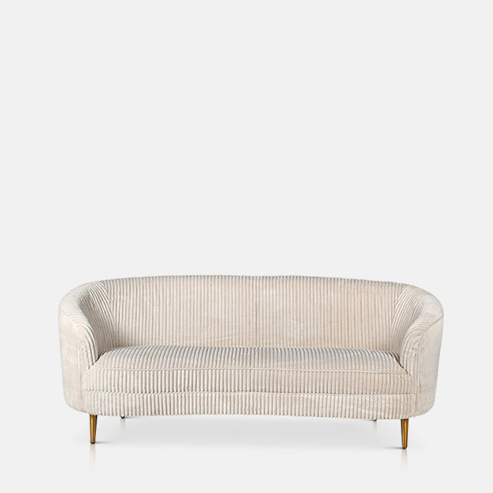 Long cream corduroy sofa with curved arms sat on four thin golden legs