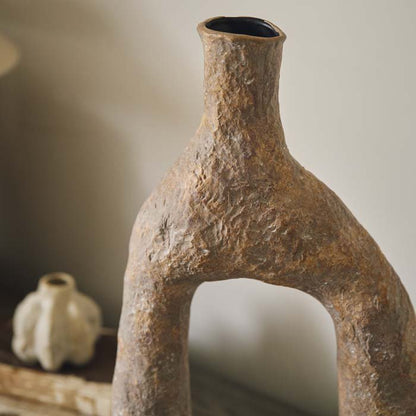 Detail image of the rough texture vase with a terracotta colour finish and abstract shape.