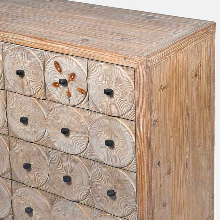 Close up of Circular pattern and black handles running down the front of the Myton Sideboard. Reclaimed pine wooden sideboard with a textured natural finish, decorative circular detailing and statement black handles. Myton Wooden Sideboard by Abigail Ahern, 