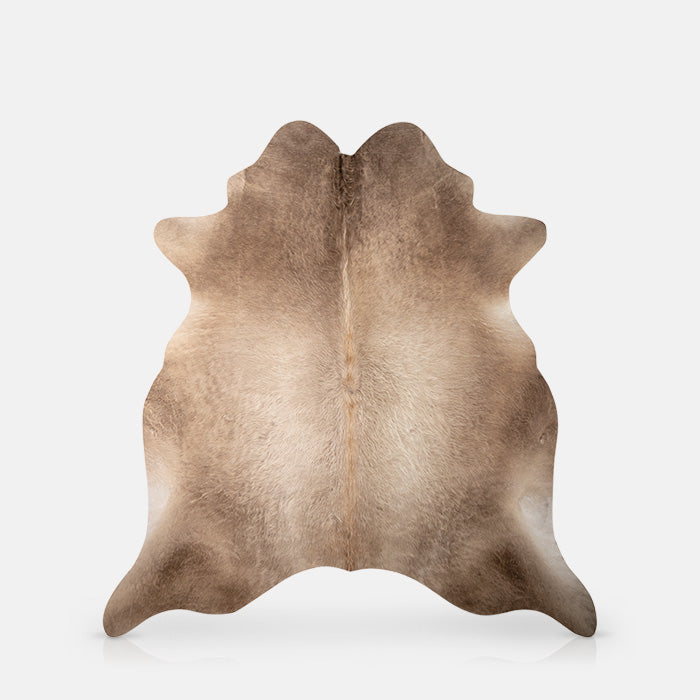 Vinyl rug with a brown cowhide print and shaped like a real cowhide