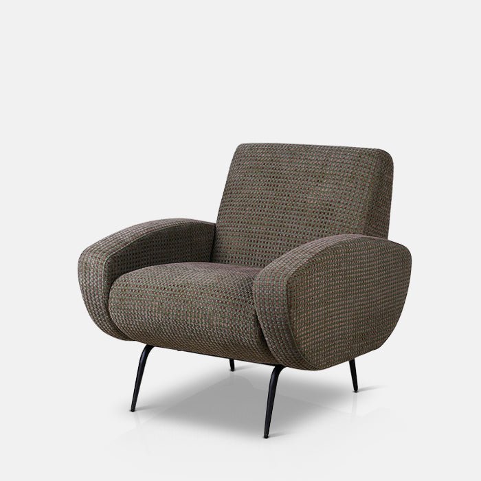 Modernist armchair upholstered in olive green-grey fabric with hints of purple, supported by four black metal legs.