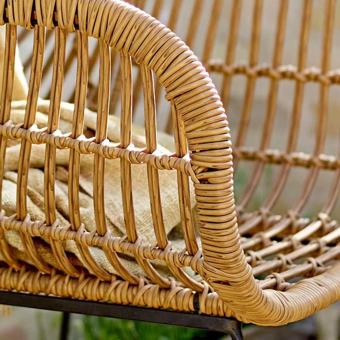 A close up of the Ormelle Lounge Chair. A polyrattan lounge chair with wide legs for stability in a black metal finish.
