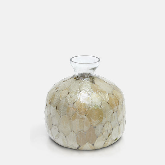 Clear glass vase, with wide curved body and narrow bottle neck, covered in green and brown dried leaves.