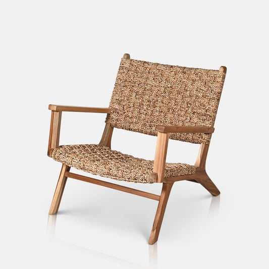 A handcrafted woven rattan armchair with a light colour wooden frame made from teak wood.