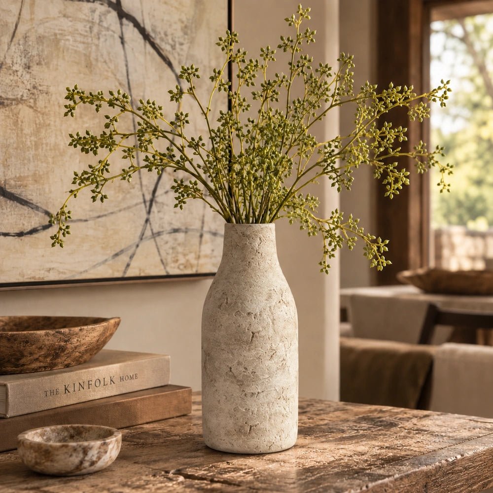 Close view of the Palmer Cement Vase showing its rounded dark cement body, rough organic texture and sculptural silhouette against a softly blurred neutral interior.