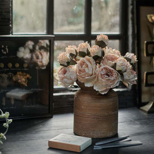 Wood-effect cement vase holding multiple stems of artificial peony flowers in a soft creamy blush tone. Luxury artificial peony flowers in a soft blush colour. These lifelike flowers add a chic look to any home decor style, and look stunning in a flower arrangement or add a natural garden flowers look to an earthy vase. Realistic artificial flowers with 2 blousy blooms and a bud on each stem.