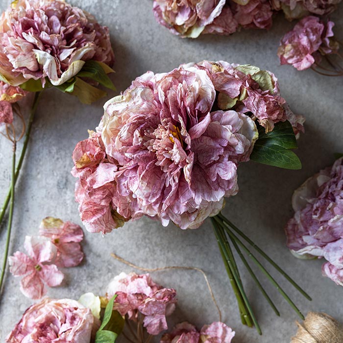A pink bunch of fake hydrangea stems tied together.