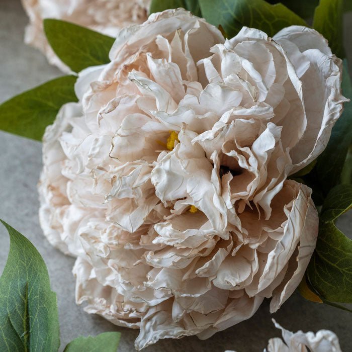 Detail image of the large pale pink head of an artificial peony flower stem.